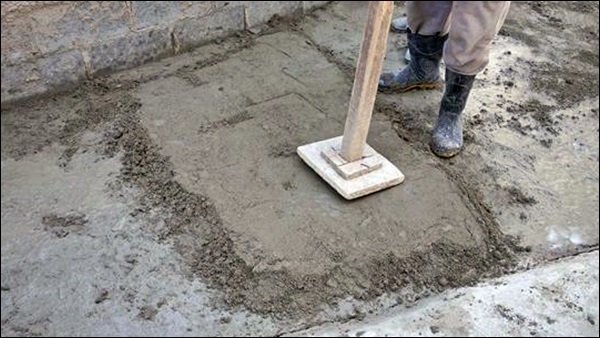 Socando a argamassa do contrapiso para o adensamento